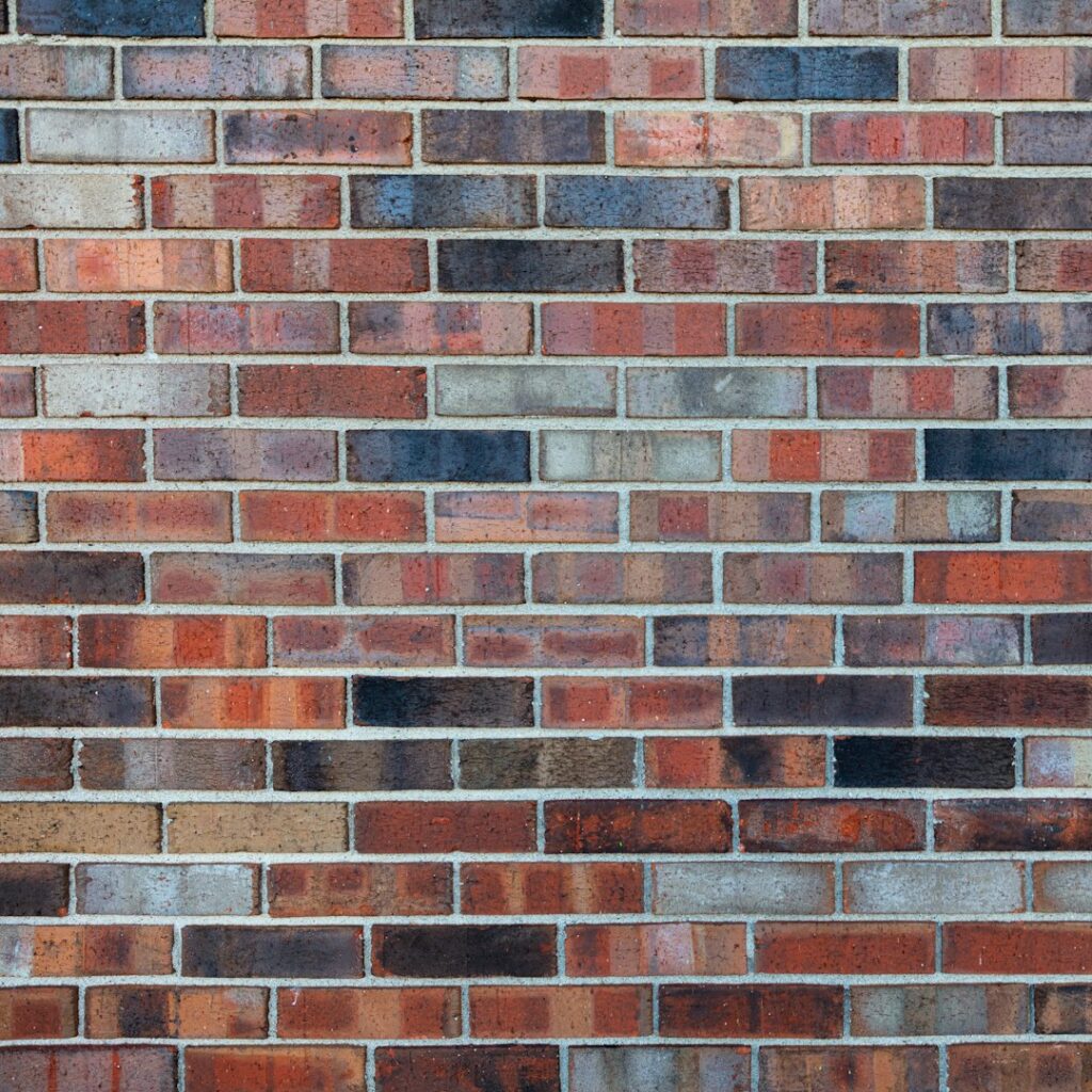 Finished red and brown brick wall with even mortar joints and staggered brick courses